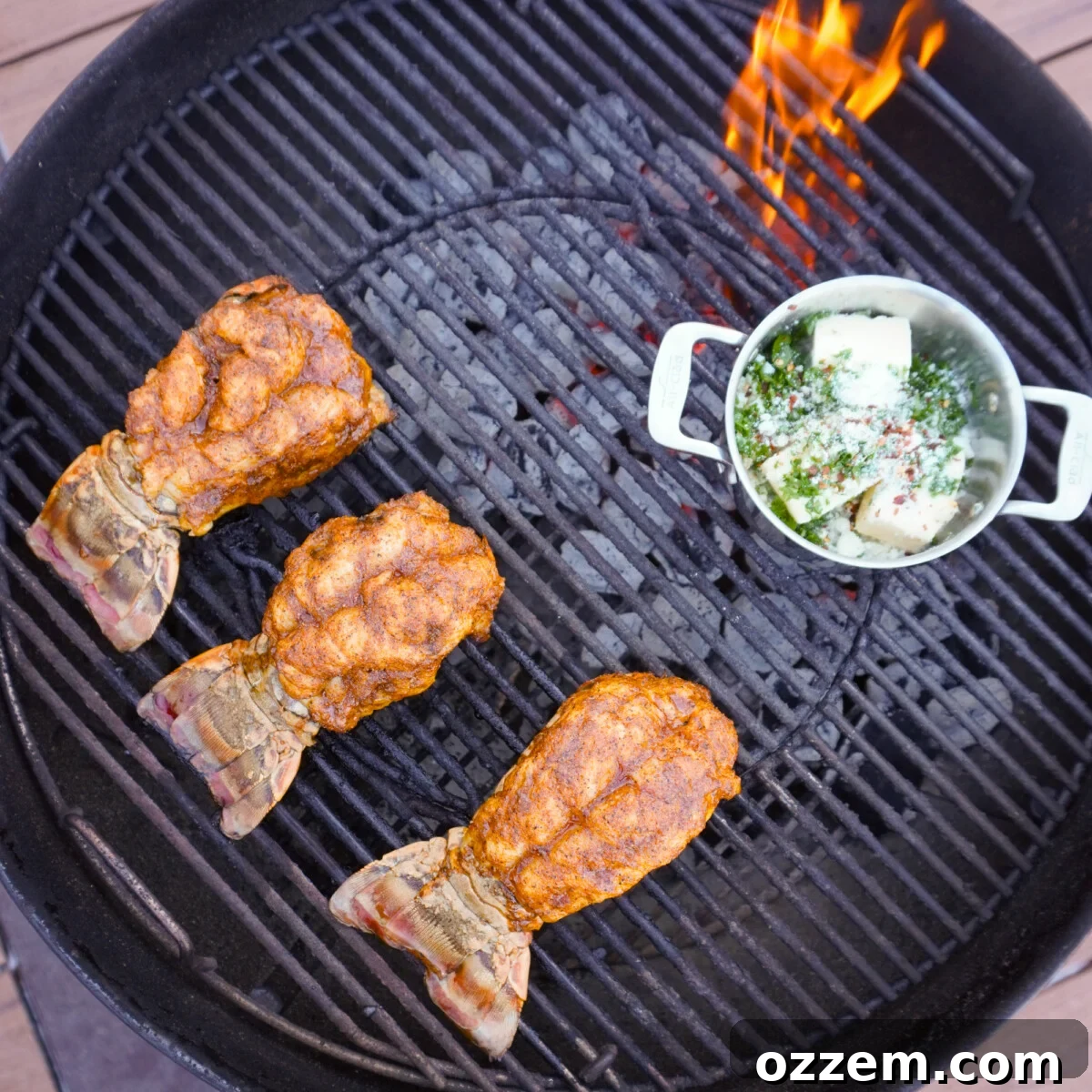 Cajun seasoned lobster tails and garlic herb butter in a saucepan on the indirect heat of the grill.