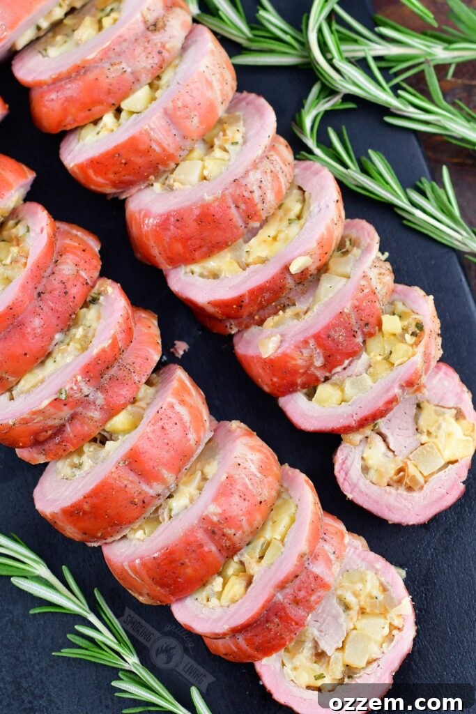 sliced smoked stuffed pork tenderloin on black board