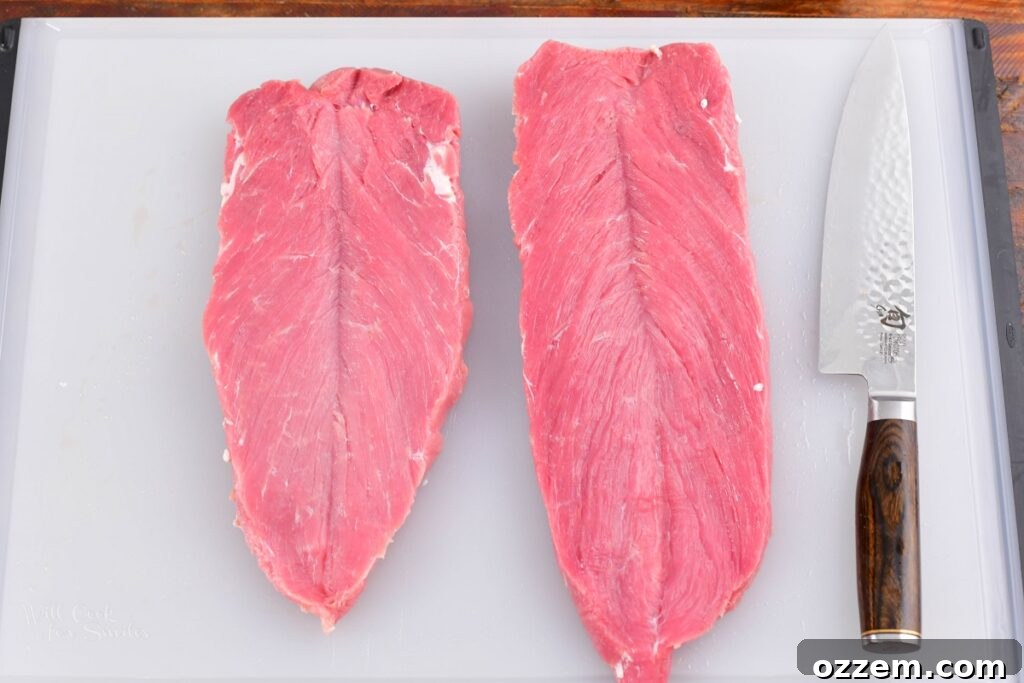 butterflied pork tenderloins on cutting board with a knife