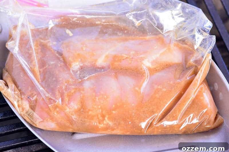Bourbon Glazed Grilled Chicken 3 Chicken breasts soaking in a homemade bourbon marinade inside a clear zip-lock bag.
