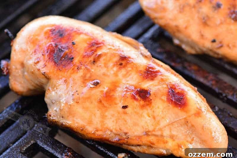 Bourbon Glazed Grilled Chicken 5 Cooked bourbon chicken breasts arranged neatly on a grill, exhibiting golden-brown skin and char marks.