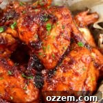close view of two glazed chicken wings in a basket
