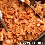 Sauced pulled chicken in a pan, ready to be served.
