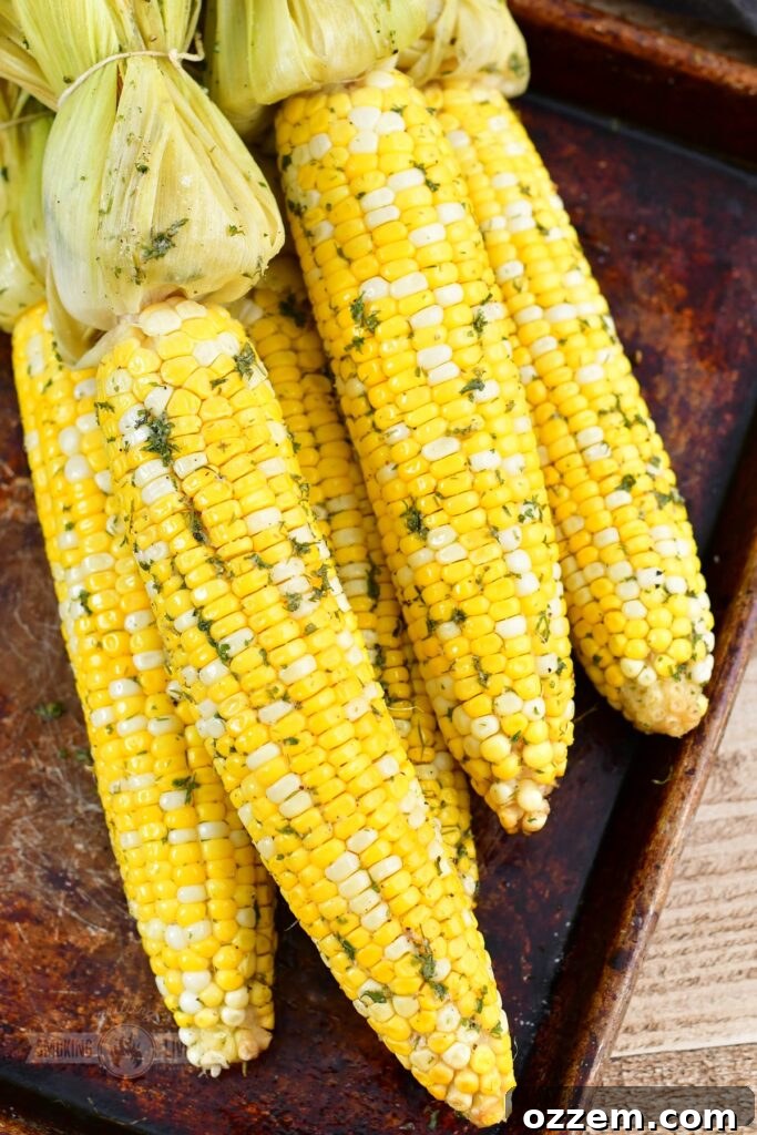 Top view of multiple smoked corn on the cob pieces arranged on a baking sheet
