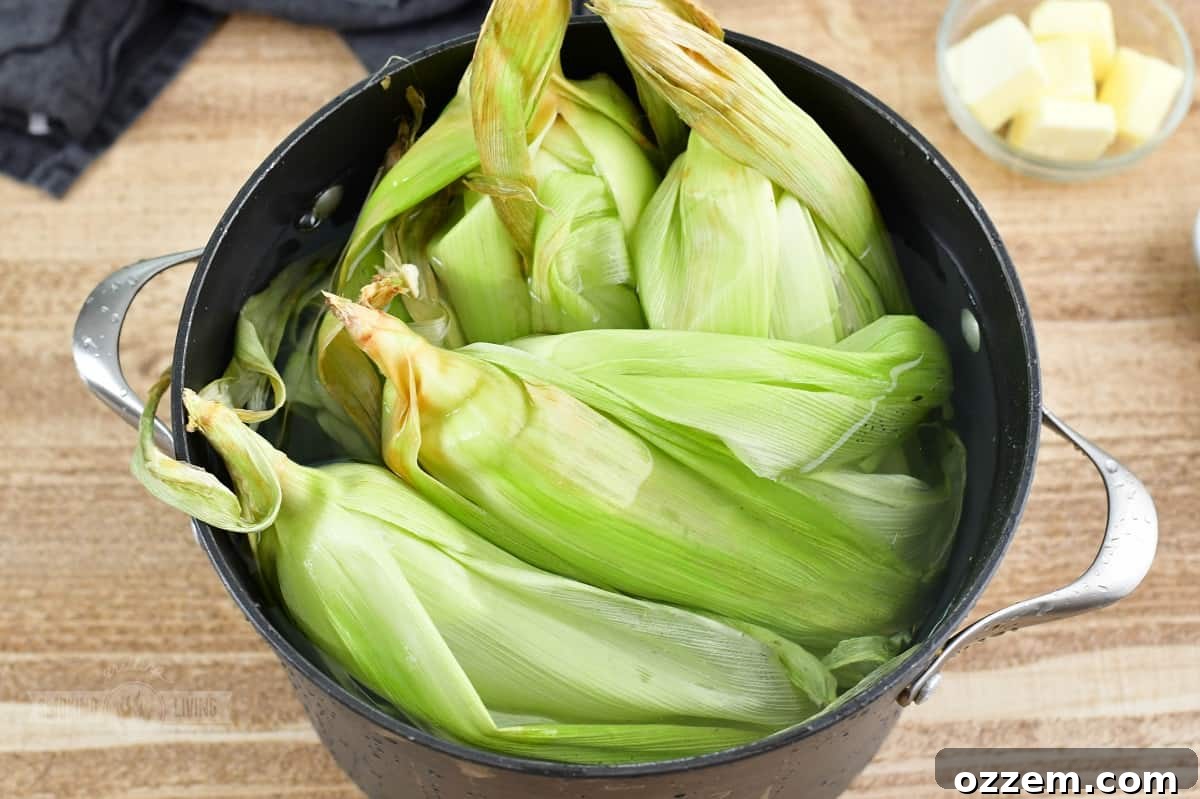 Corn on the cob soaking in a large pot of cold water