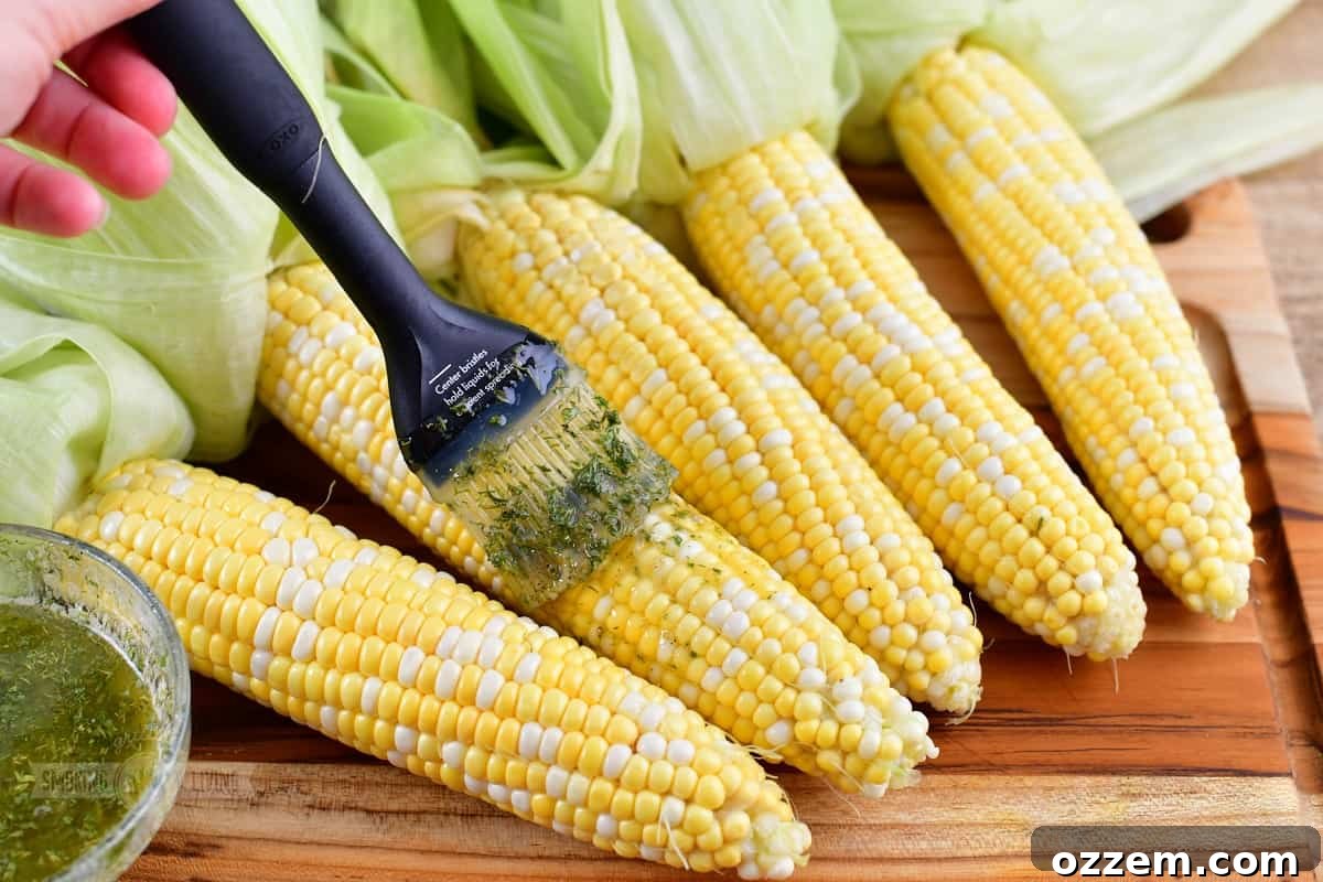 Applying melted butter and seasoning mixture to corn on the cob with a brush