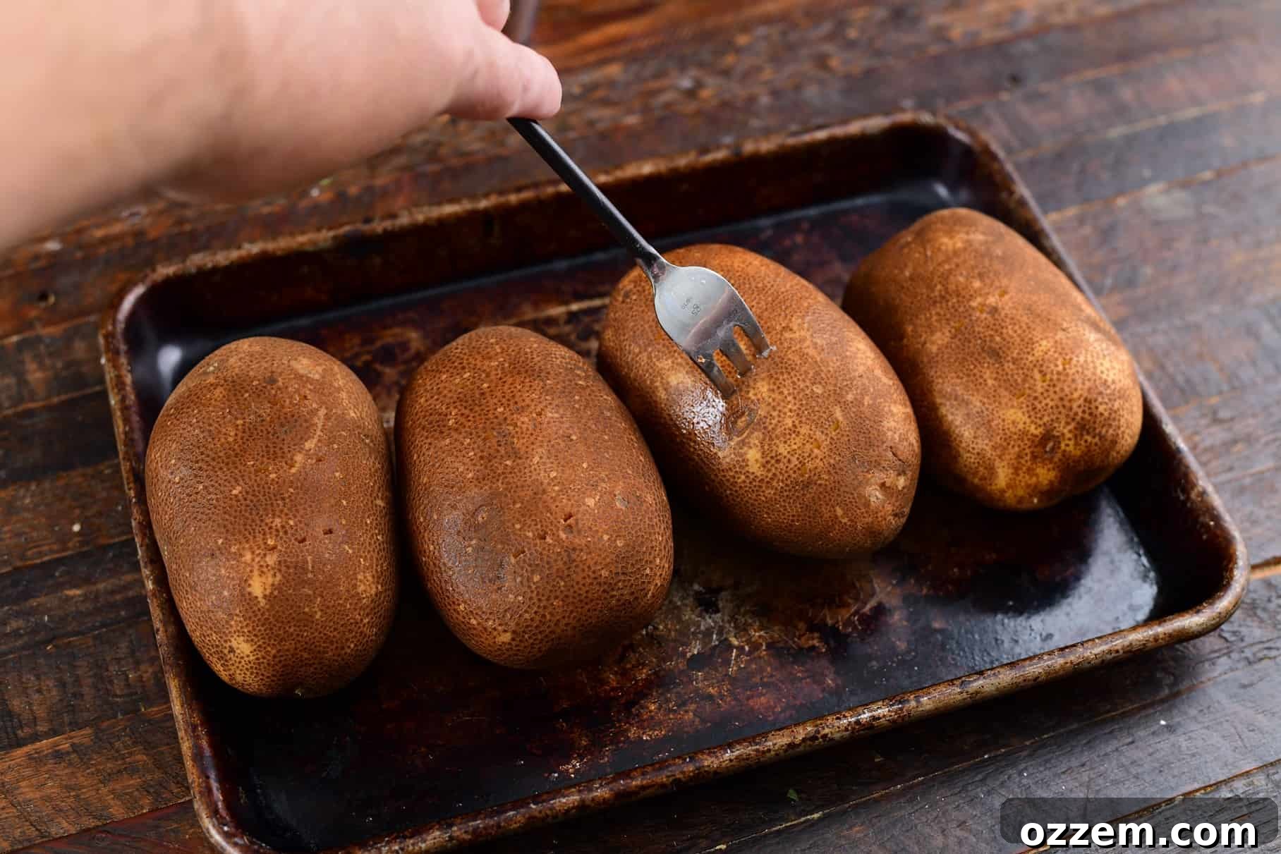 A fork poking holes into a potato, a crucial step for proper smoking.