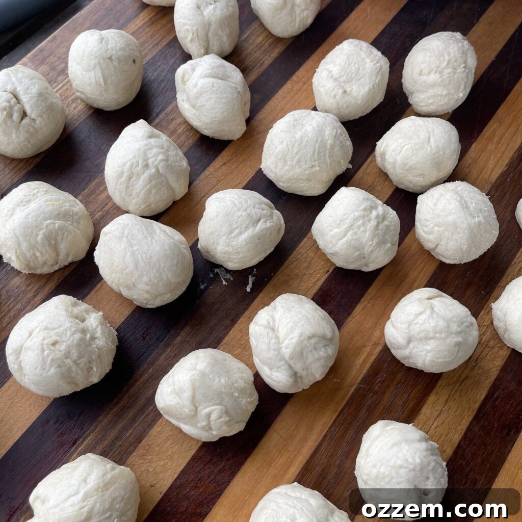 Rolled biscuit dough balls ready for dipping.