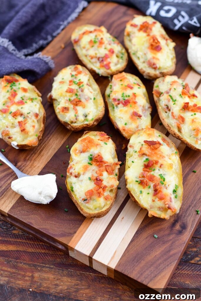 Smoky Creamy Twice Baked Potatoes 2 Twice smoked baked potatoes on a wood board with sour cream and chives