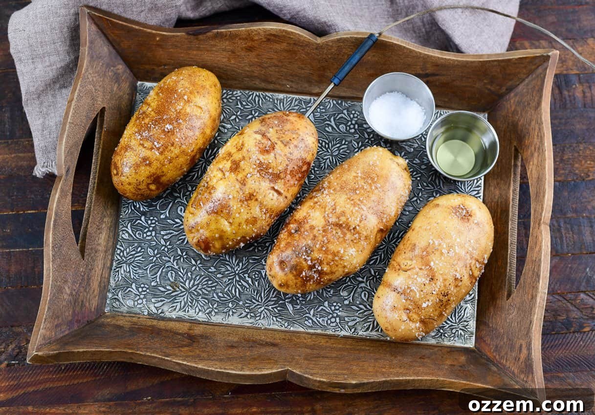 Smoky Creamy Twice Baked Potatoes 6 raw potatoes oiled and salted on a tray with a probe inserted