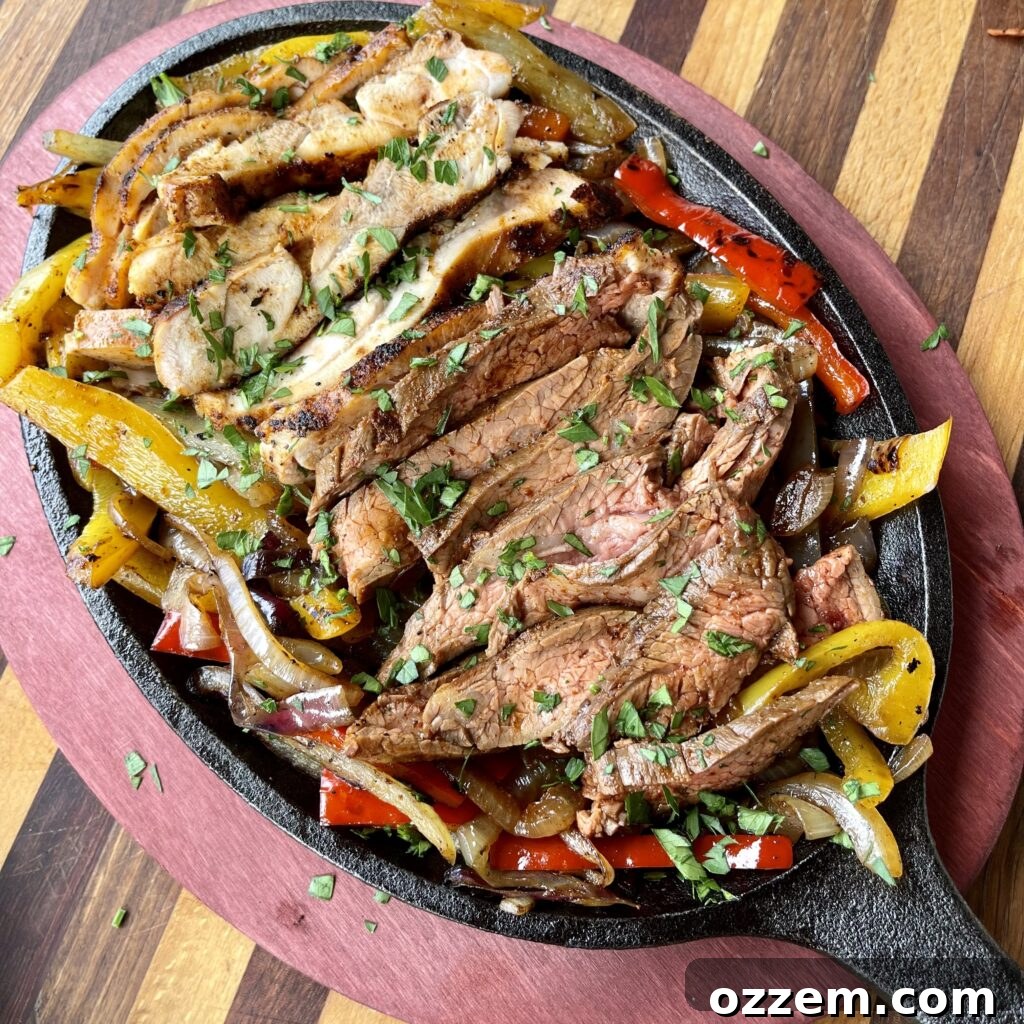 Sizzling Chicken and Steak Fajitas 2 Sizzling chicken and steak fajitas with colorful bell peppers and onions on a griddle