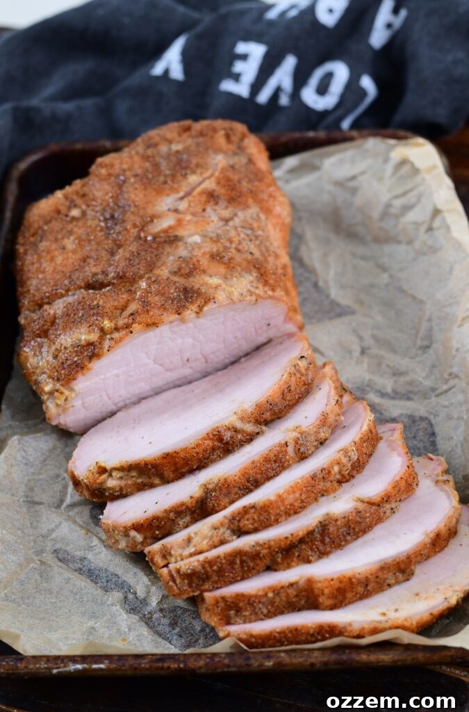 Wood-Fired Pork Loin Perfection 2 Beautifully smoked pork loin, sliced and ready to serve on a cutting board.
