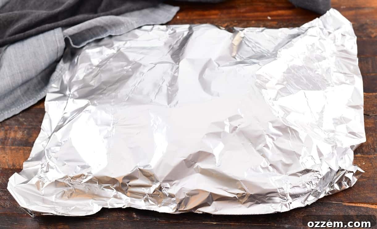 Wood-Fired Pork Loin Perfection 14 The smoked pork loin resting under foil after being removed from the smoker.