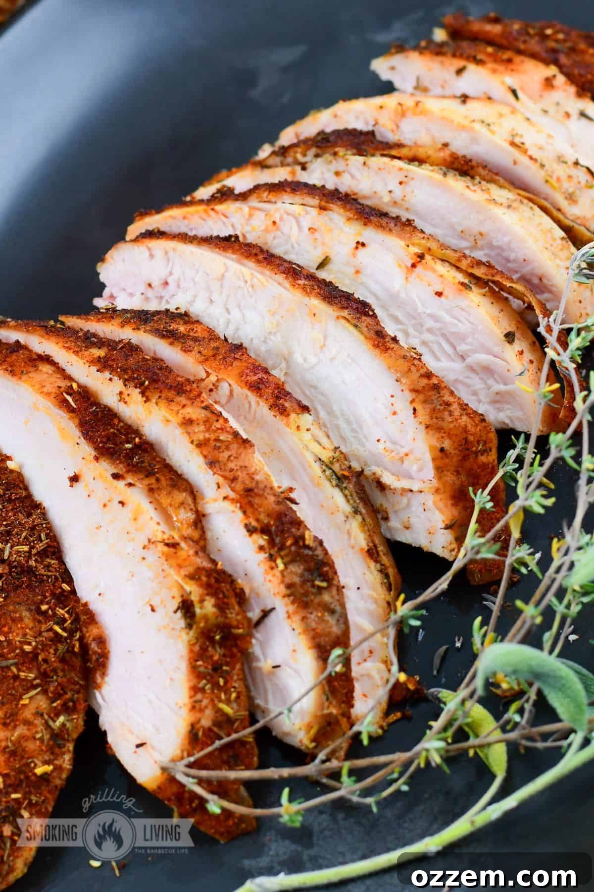 Beautifully thinly sliced smoked turkey breast arranged on a black plate, garnished with fresh herbs for an elegant presentation.