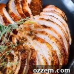Thinly sliced turkey breasts stacked on a black platter.