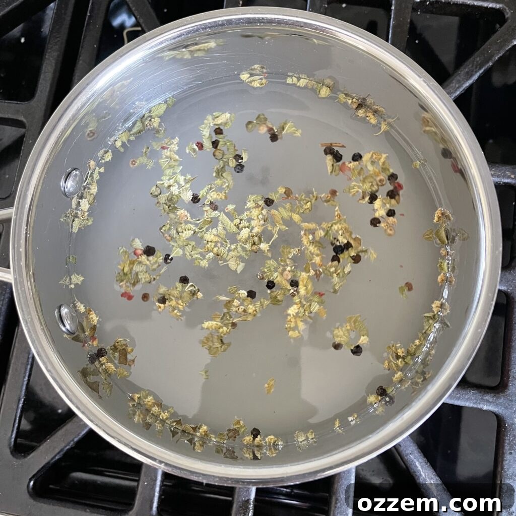 Zesty Jalapeno Slices 4 Hot pickling brine simmering in a saucepan with spices.