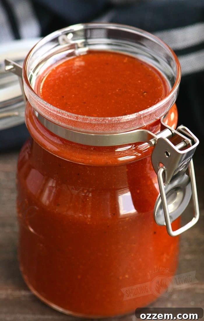 Close-up shot of homemade BBQ sauce in a glass jar, highlighting its rich color and inviting texture.