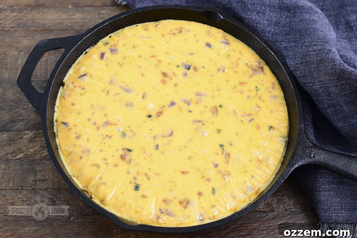 Campfire Queso Dip 15 Freshly smoked queso dip taken directly from the pit, showcasing its golden crust and bubbling interior.