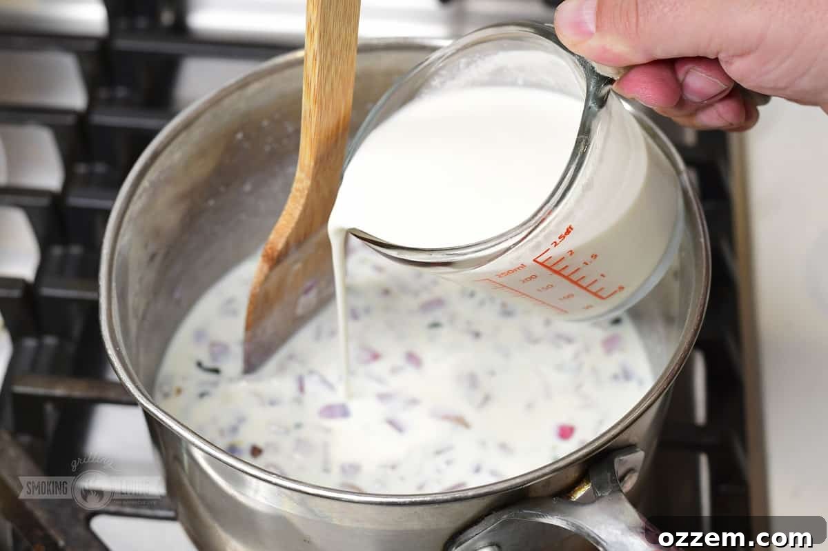 Campfire Queso Dip 8 Whole milk being poured into the saucepan with smoked vegetables and flour, ready to be stirred into the base.