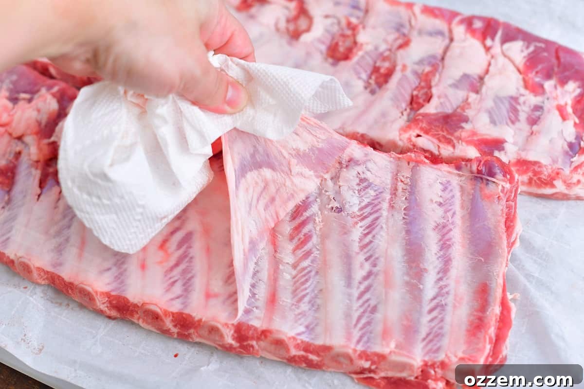 pulling off the membrane from the back of St. Louis ribs for tender results