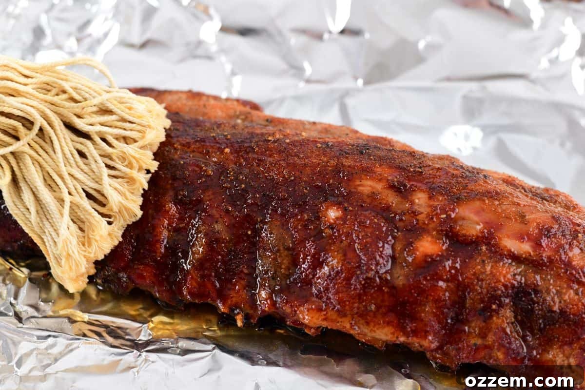 applying mop sauce to 321 ribs before wrapping