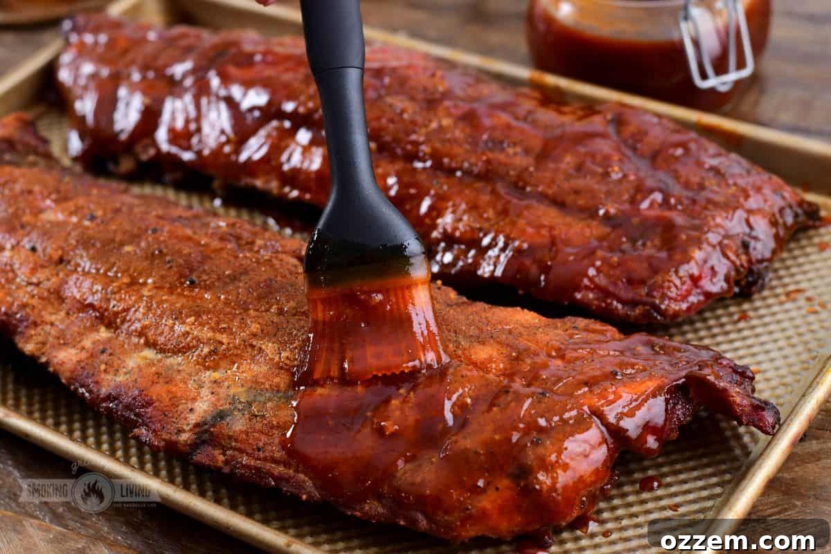 321 ribs being generously basted with BBQ sauce