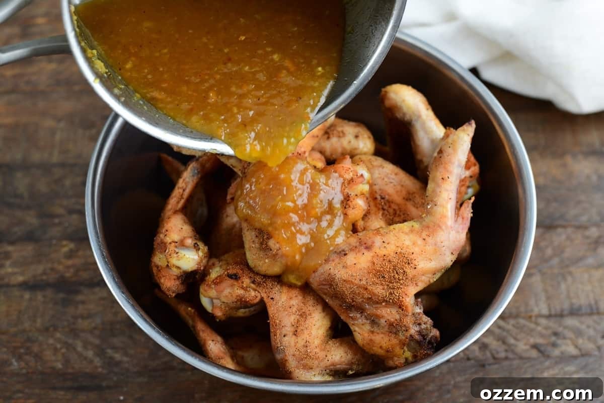 Sauce being added to wings before saucing.