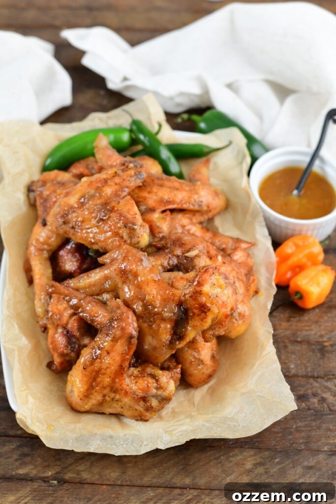 Sauced smoked bourbon peach wings on paper on a plates.