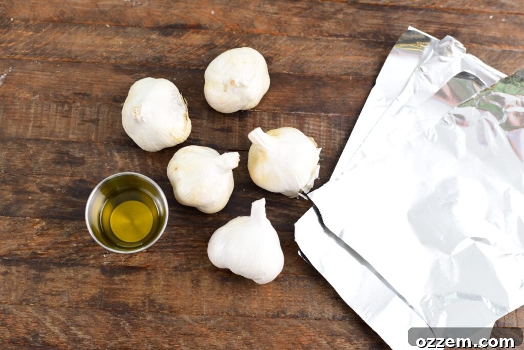Two bulbs of garlic and a bottle of olive oil, the simple ingredients for smoked roasted garlic.