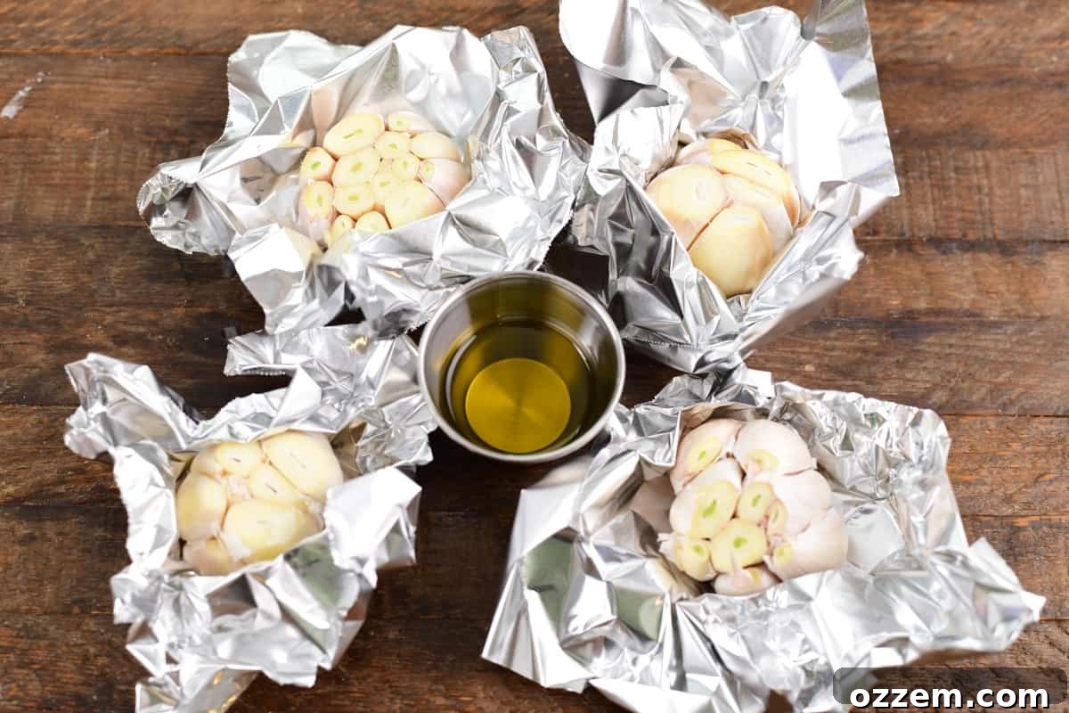 Garlic bulb in foil with olive oil poured over the top, ready for smoking.