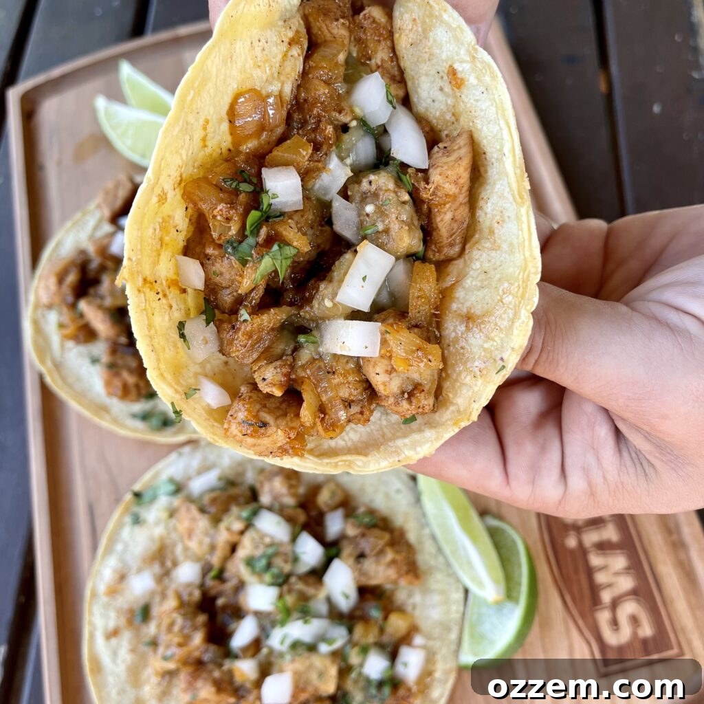 Effortless Pork Tacos 5 Platter of finished easy pork tacos with a side of fresh cilantro, diced onions, and salsa verde