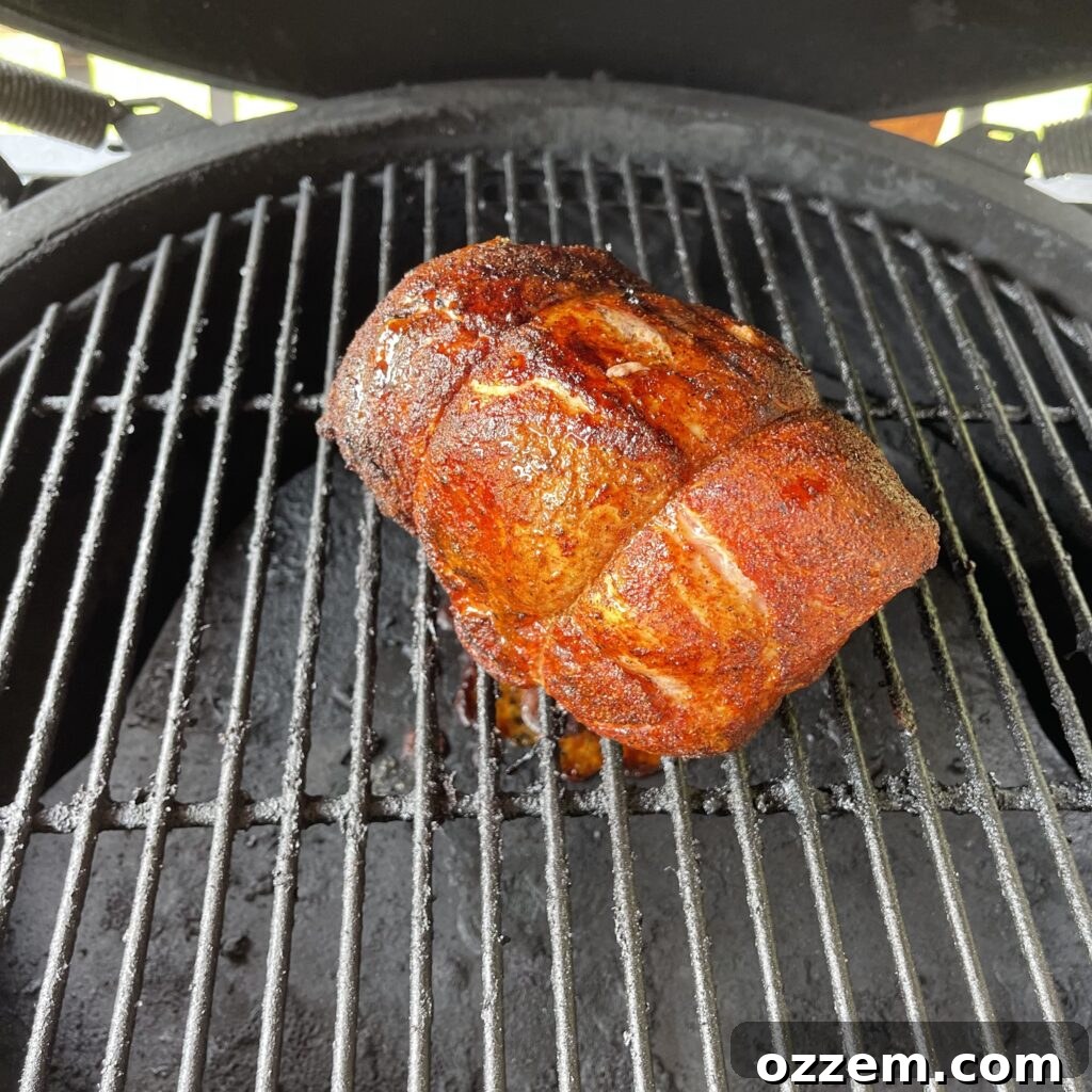 Smoked pork roast resting on a cutting board, ready to be sliced