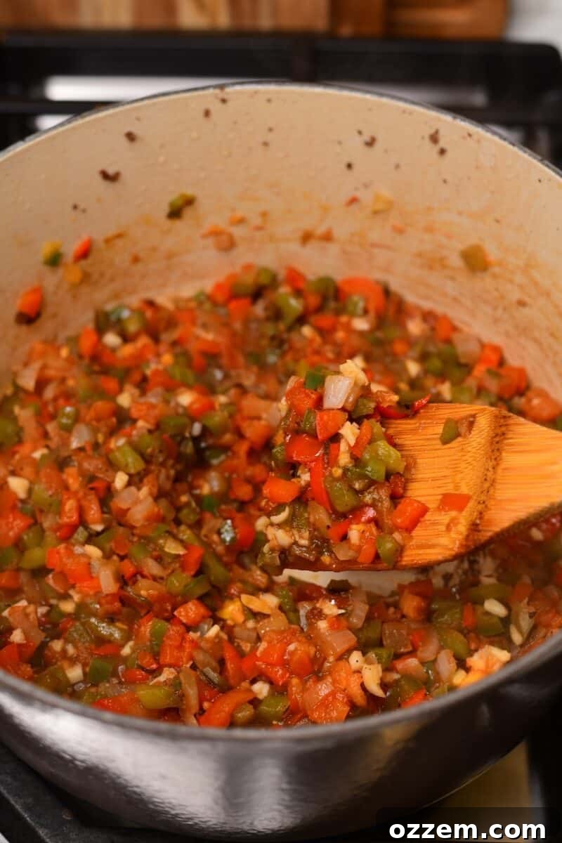 Cooked veggies on a wooden spoon above pot.