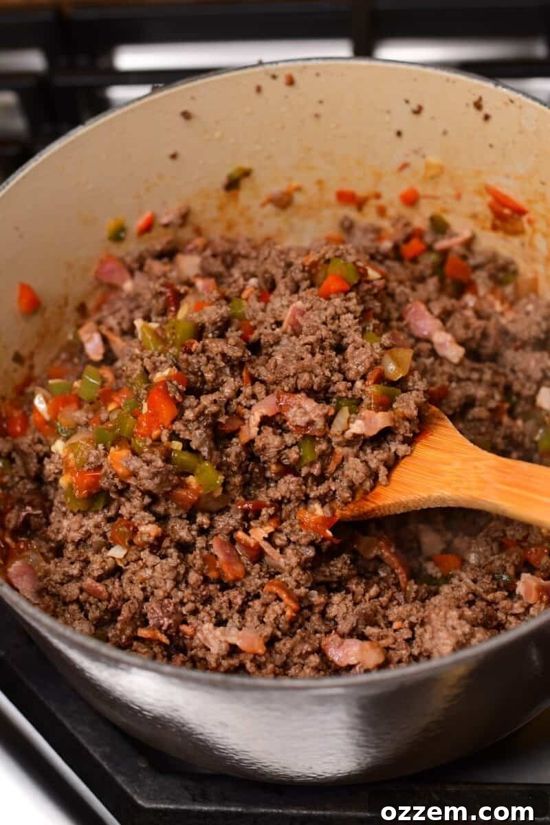 Cooked beef and veggies being held up on a wooden spoon,