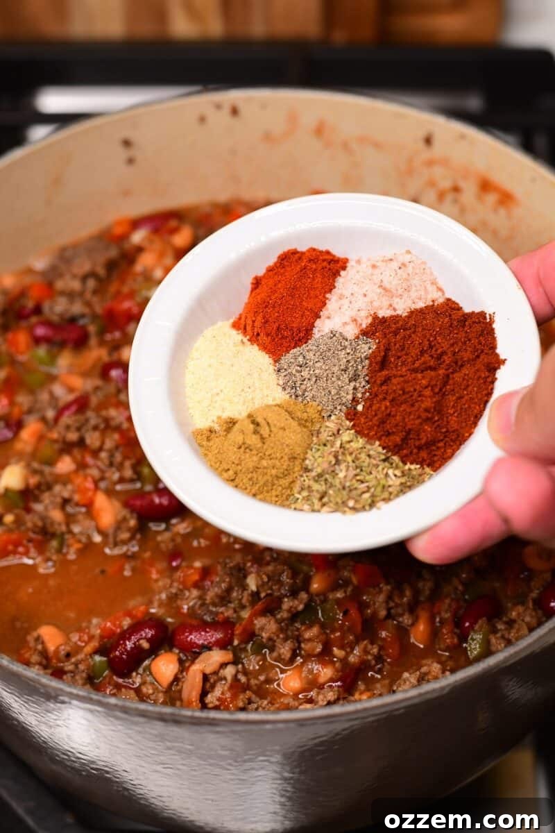 Seasonings held over the cooking chili.