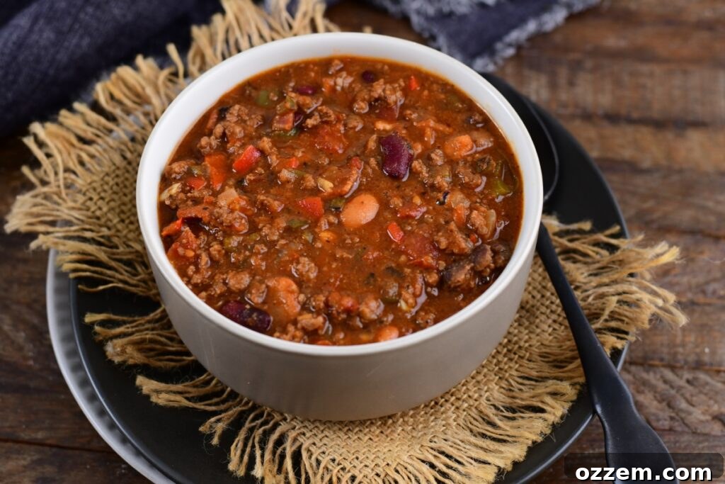 Chili in a white bowl with no toppings.
