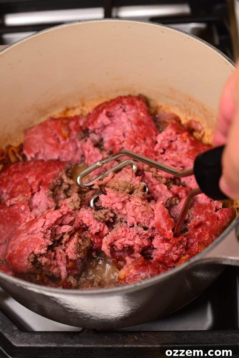 Pre smoked ground beef in pot with bacon being broken up