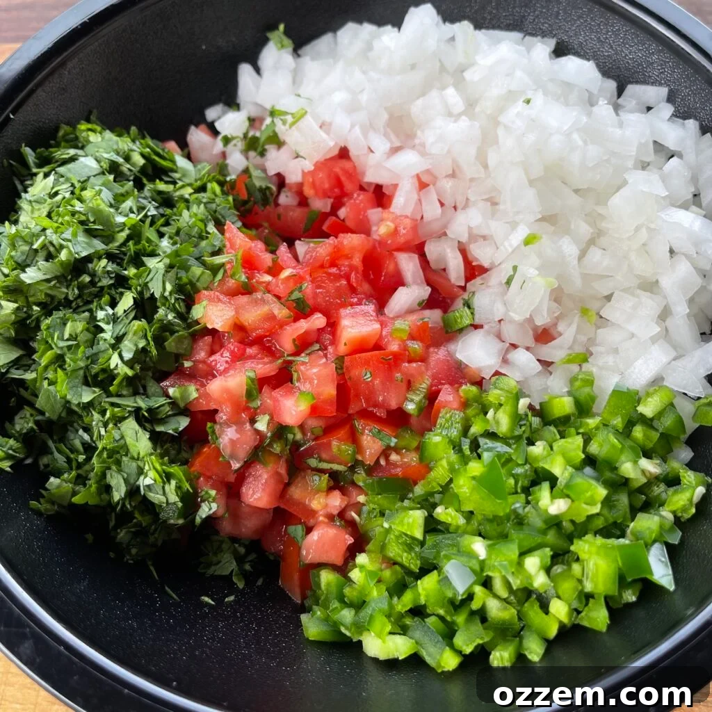 Freshly chopped ingredients for pico de gallo: vibrant tomatoes, crisp onions, spicy jalapenos, and aromatic cilantro.