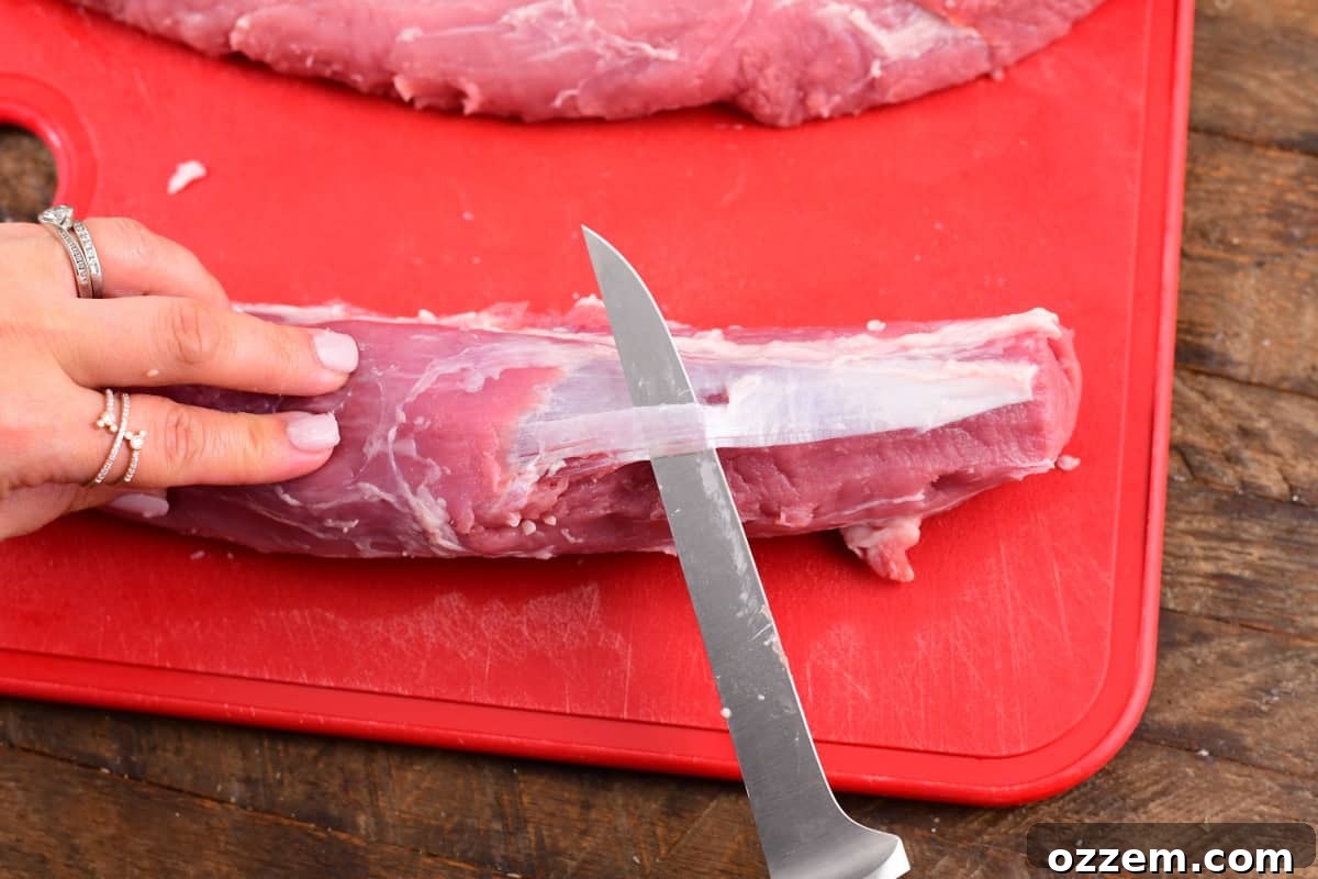Slow-Smoked Pork Perfection 4 Trimming the silver off the pork tenderloin still raw