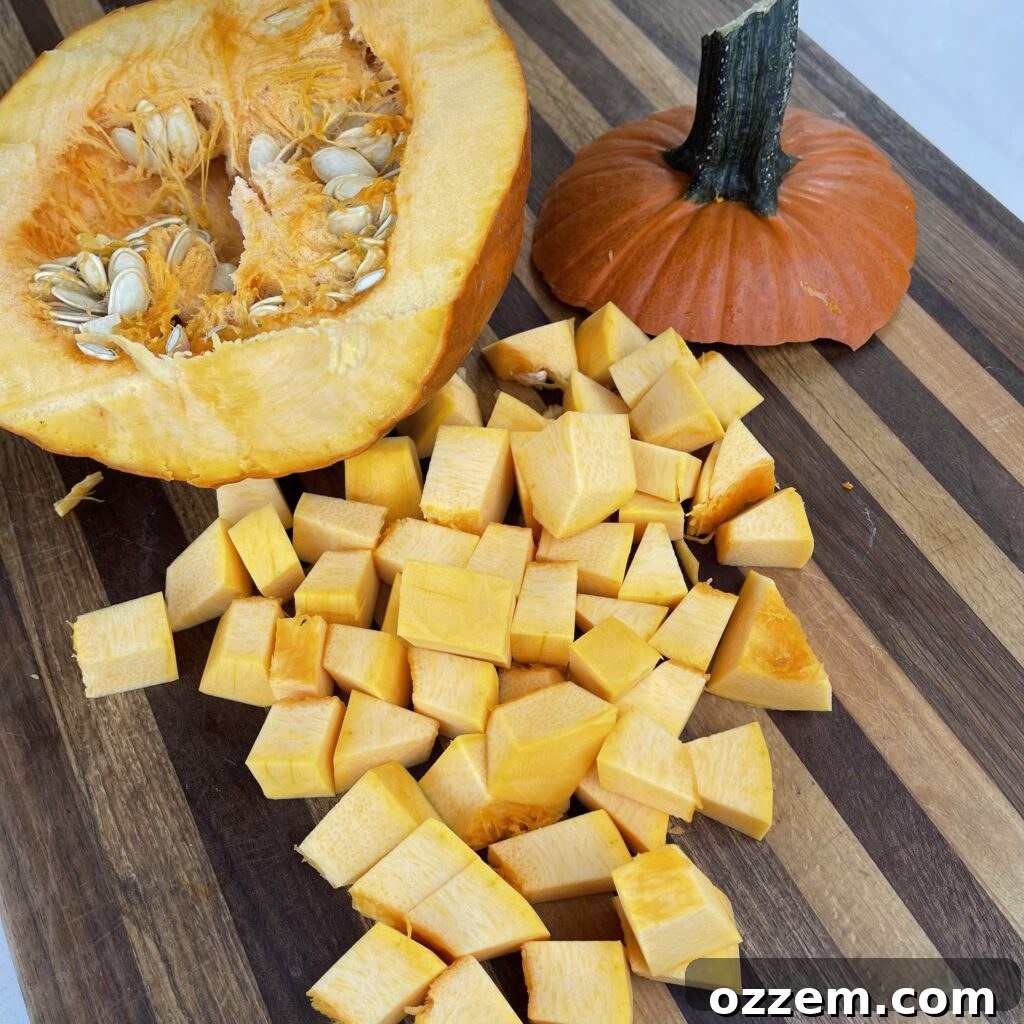 Half of a small pumpkin, neatly cut and ready for further preparation, showcasing its bright orange flesh and seeds.