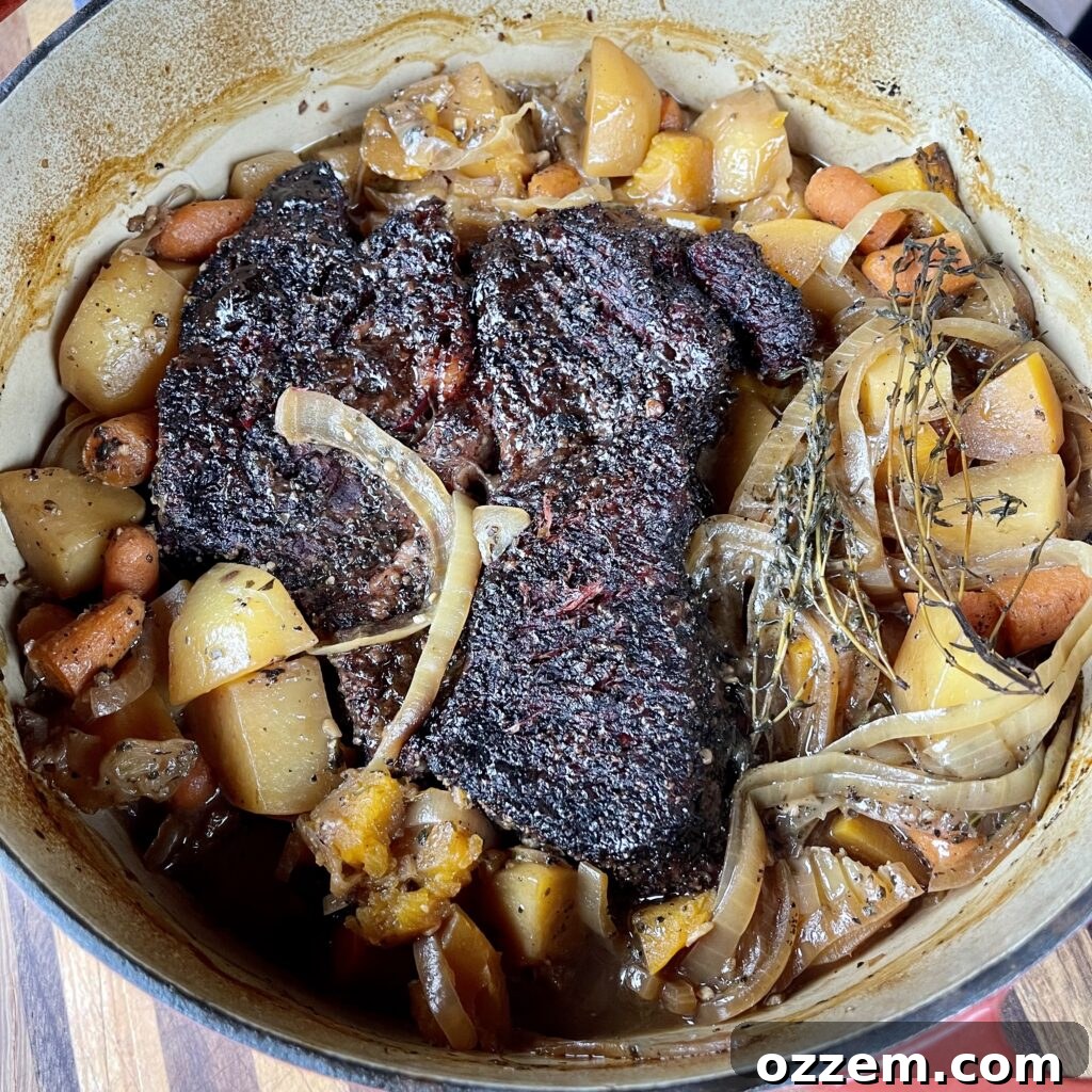 A close-up shot of a richly braised pumpkin beef stew simmering in a rustic Dutch oven, the beef and vegetables tender and submerged in a flavorful, thick sauce.