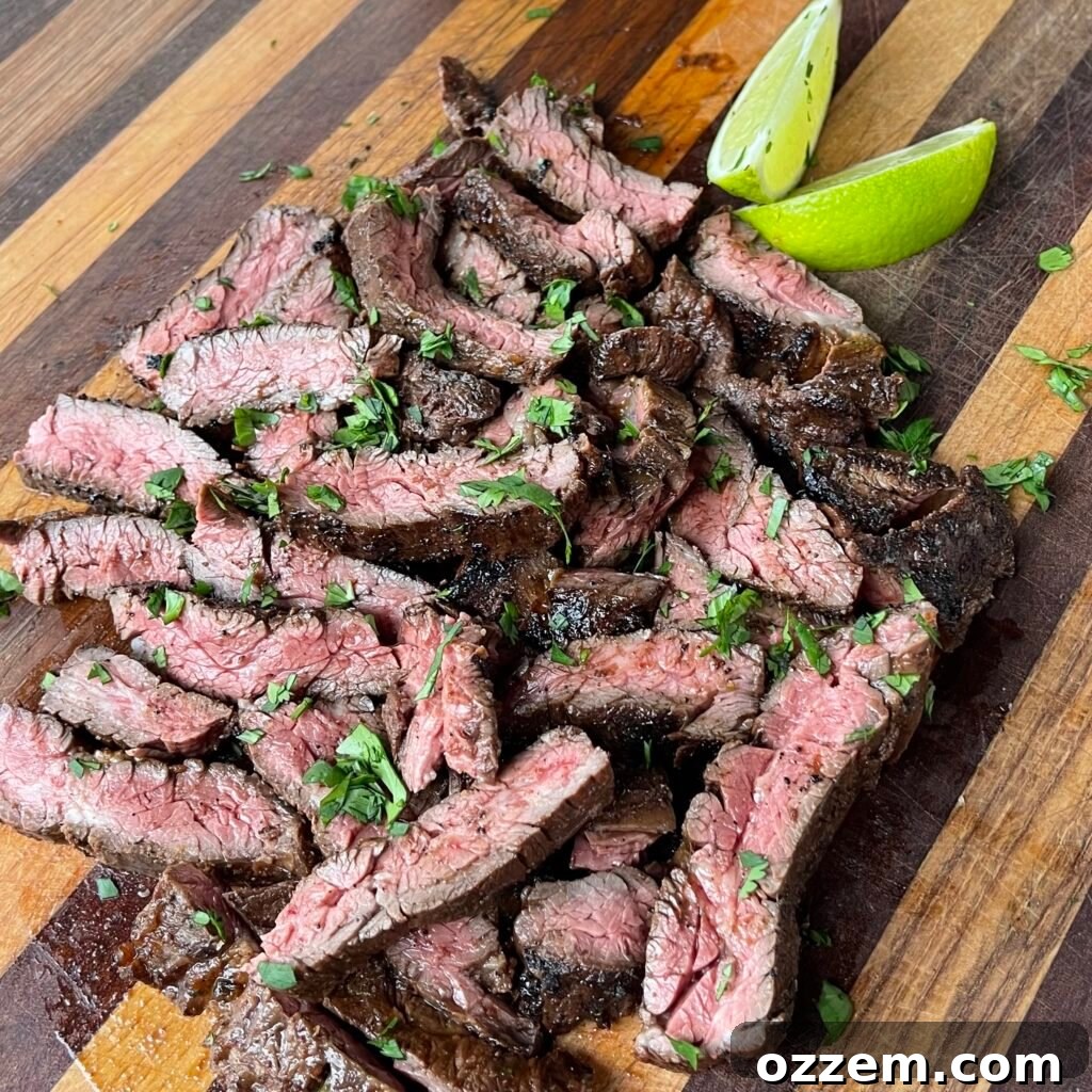 Perfectly grilled Tequila Lime Skirt Steak, sliced against the grain and ready to be served on a wooden board.
