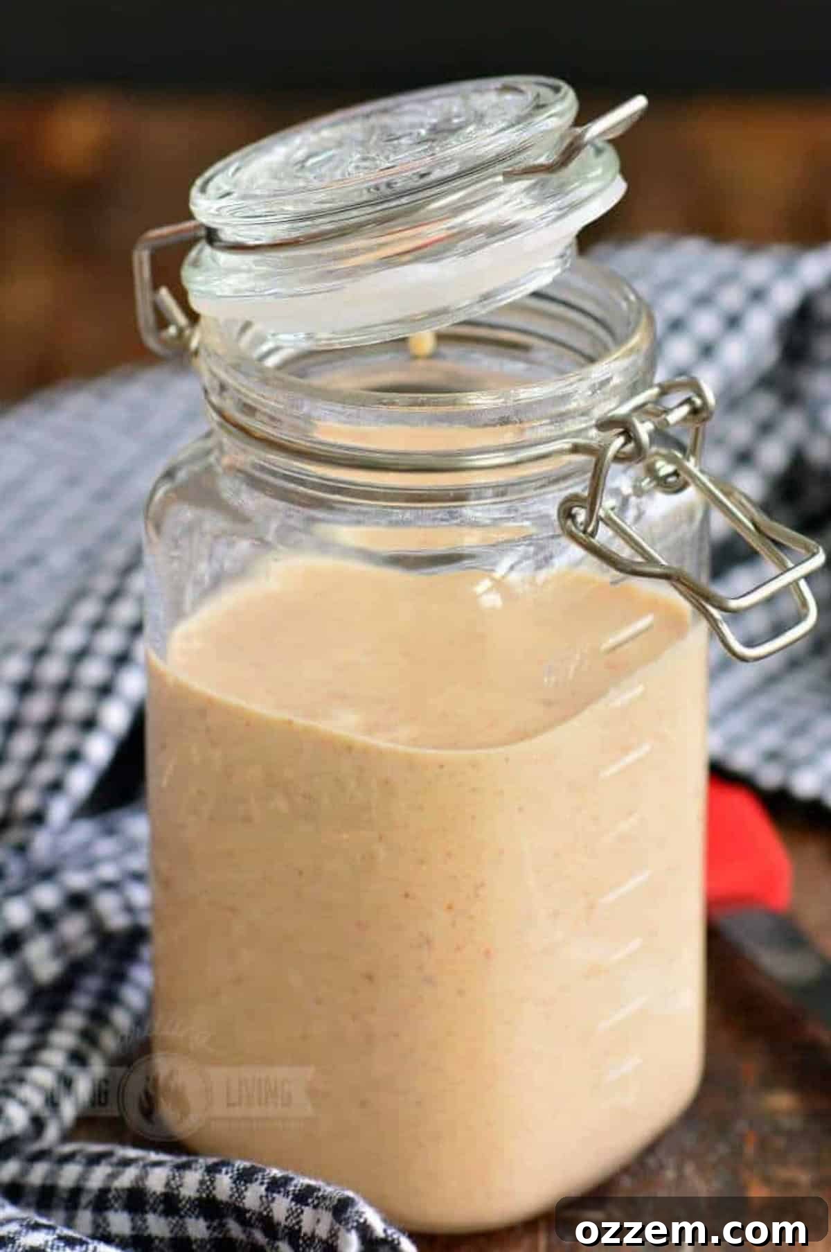 Southern Creamy White BBQ 2 White BBQ sauce in a jar with the lid partially closed.