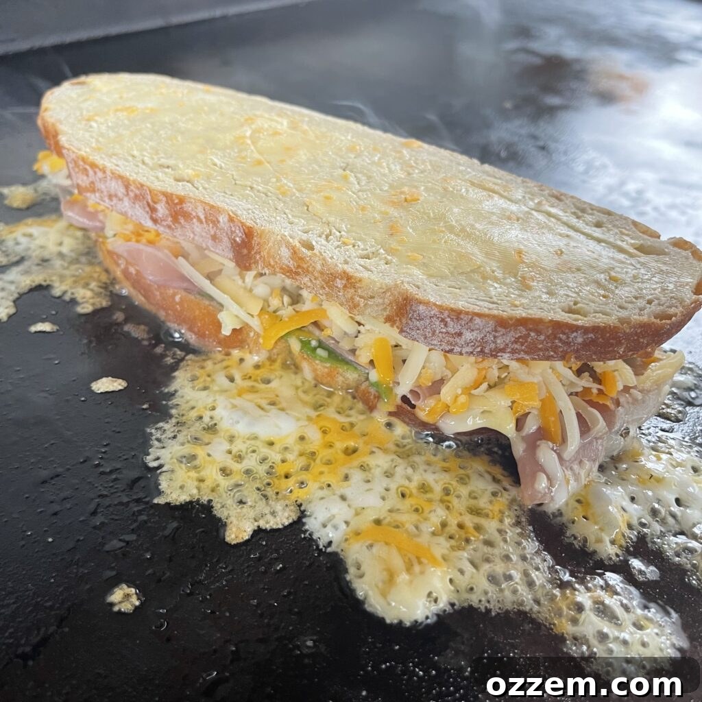 Assembling a pesto and prosciutto grilled cheese