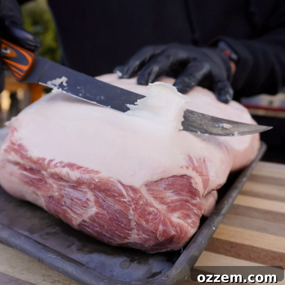 Timeless Pulled Pork Perfection 4 Trimming excess fat off a pork shoulder before seasoning.