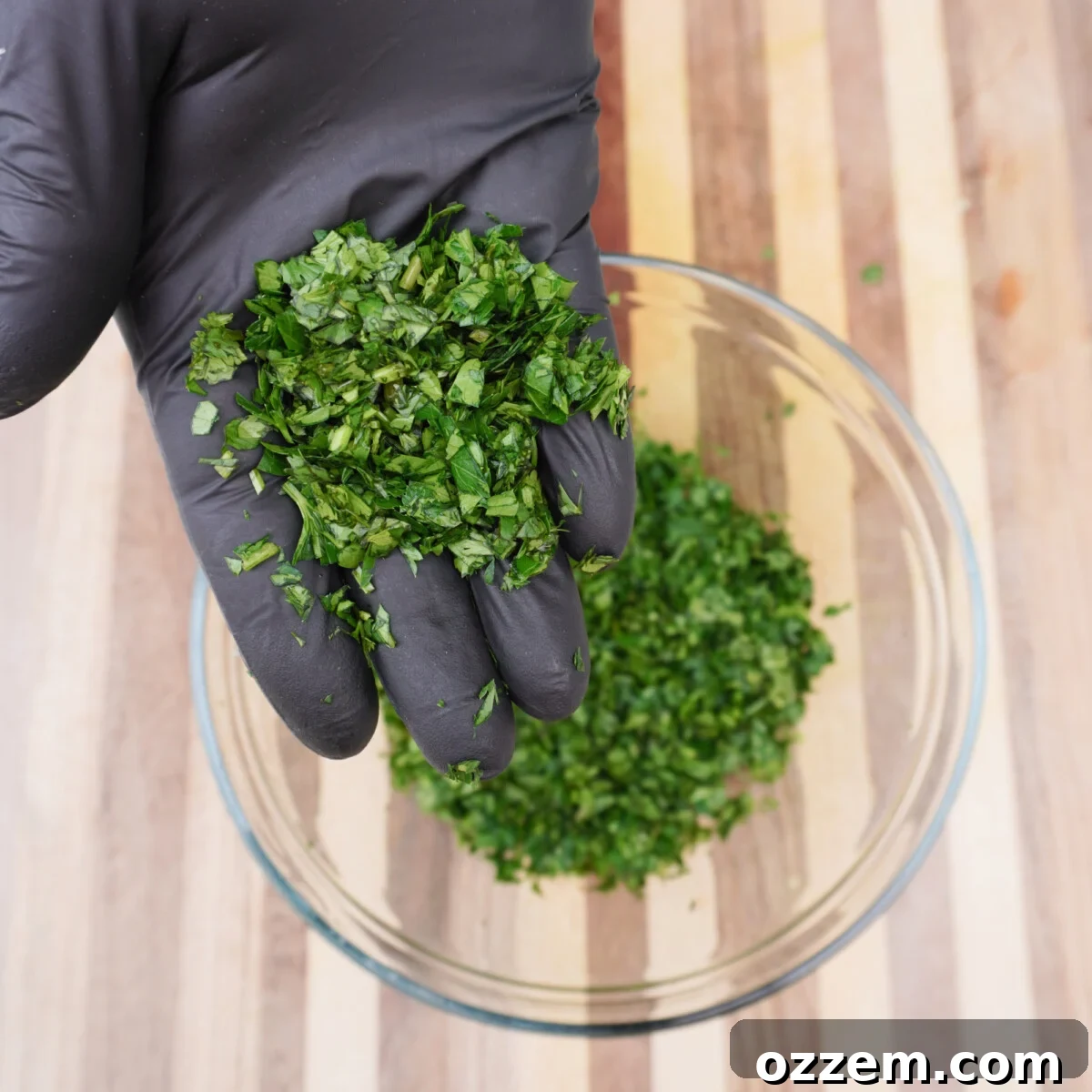 Finely chopped fresh herbs, parsley and cilantro, on a cutting board.