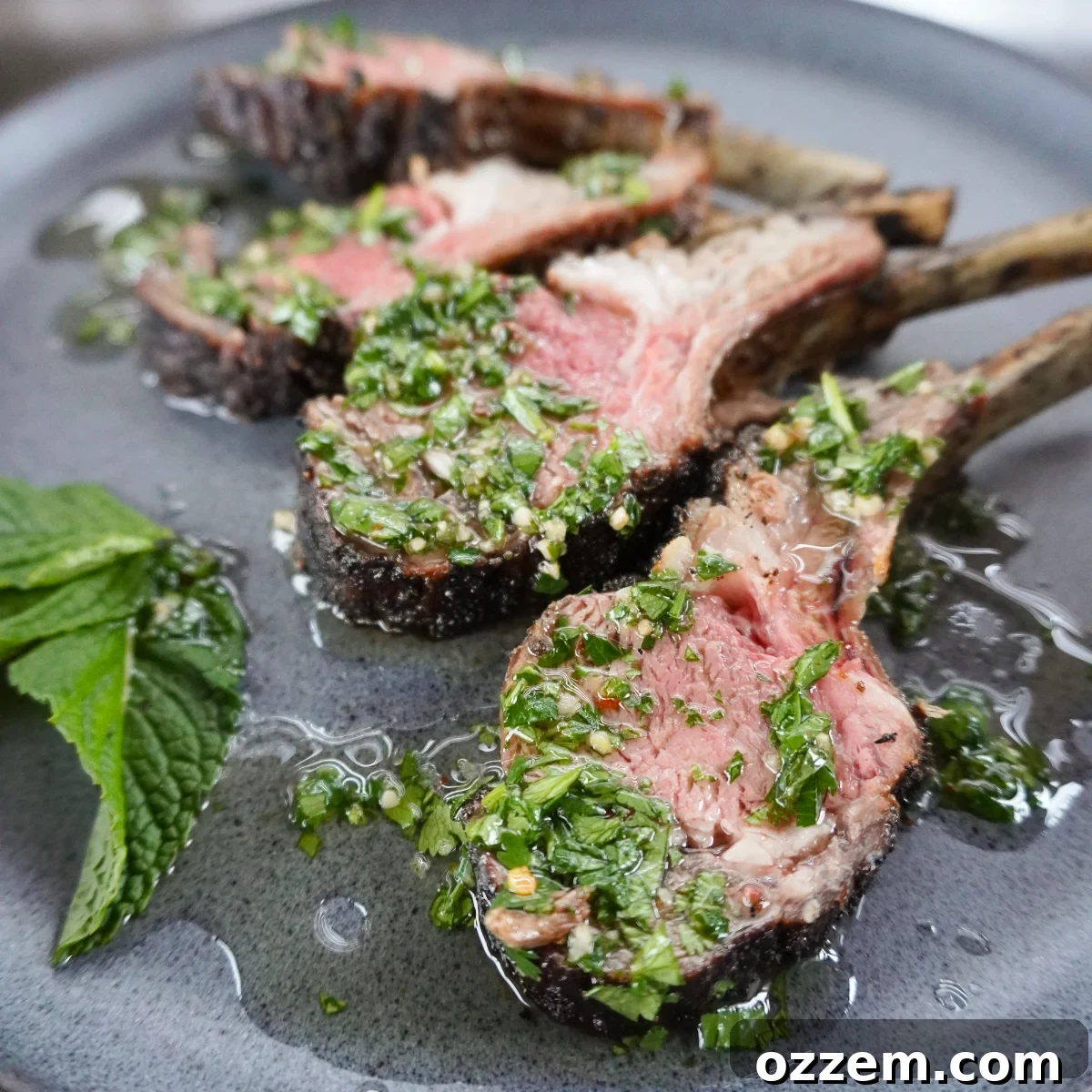 Perfectly grilled rack of lamb adorned with a vibrant mint chimichurri sauce.