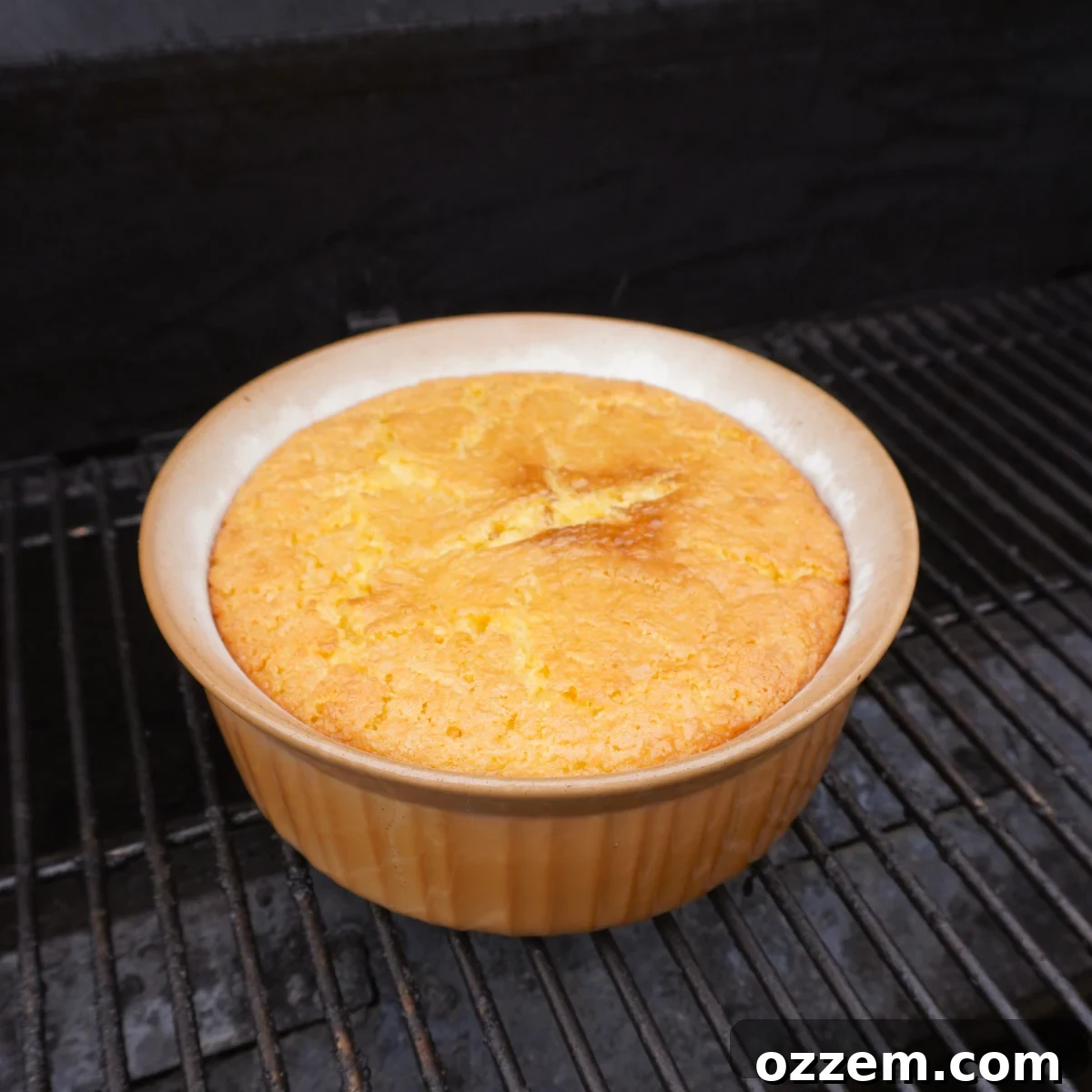 Golden Creamy Corn Bake 5 A hot cream corn casserole baking on a grill, showcasing its golden-brown top.