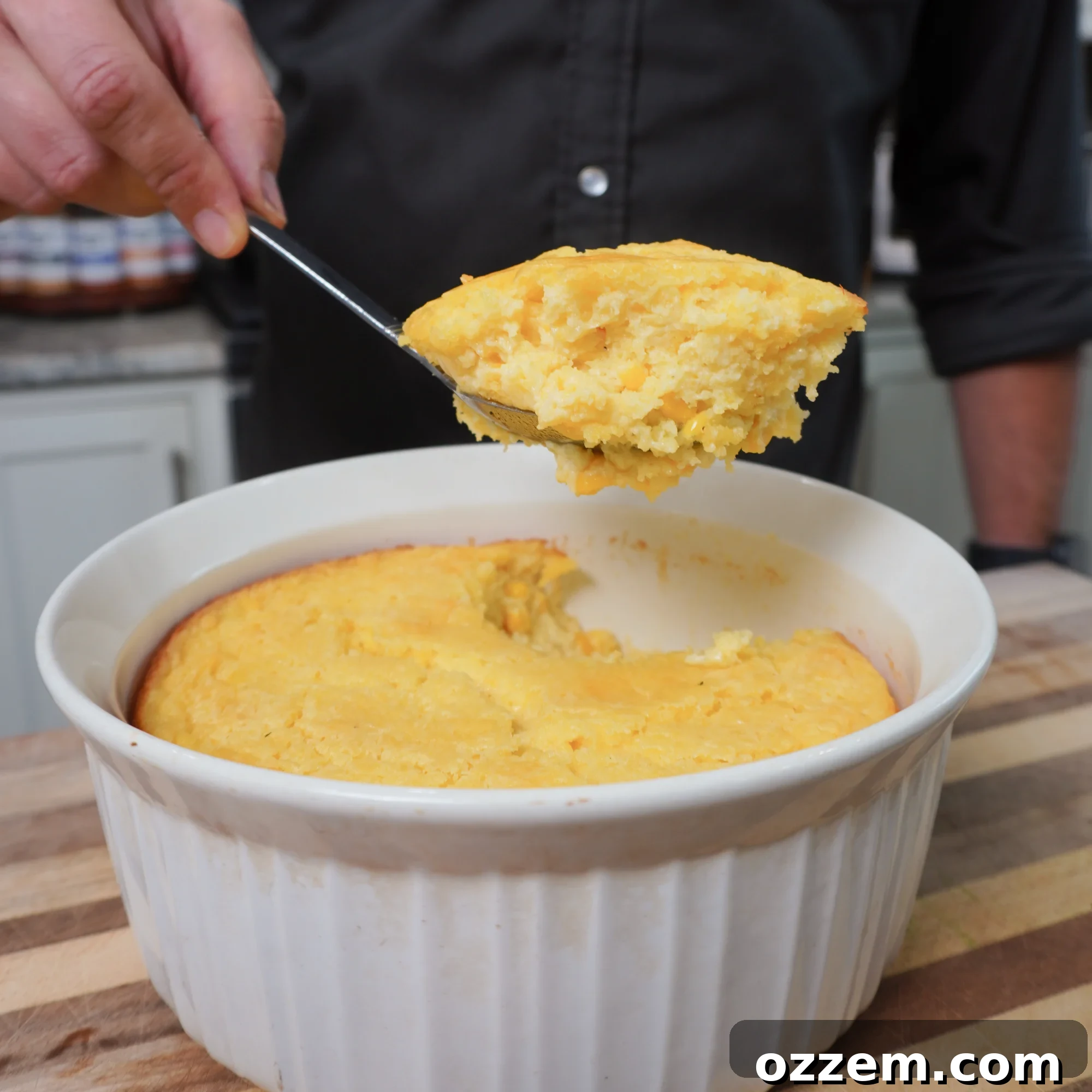 Golden Creamy Corn Bake 6 A generous scoop of the creamy corn casserole in a serving bowl, showcasing its rich texture.