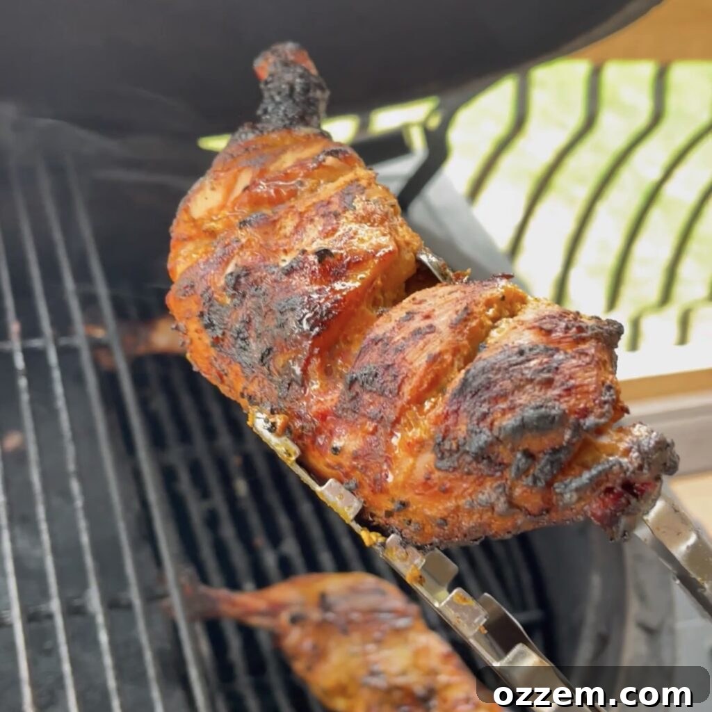 Grilled Tandoori chicken quarters cooking on a barbecue